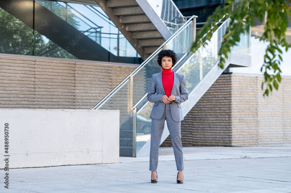 Una elegante mujer afroamericana con pelo corto en un  edificio de oficinas