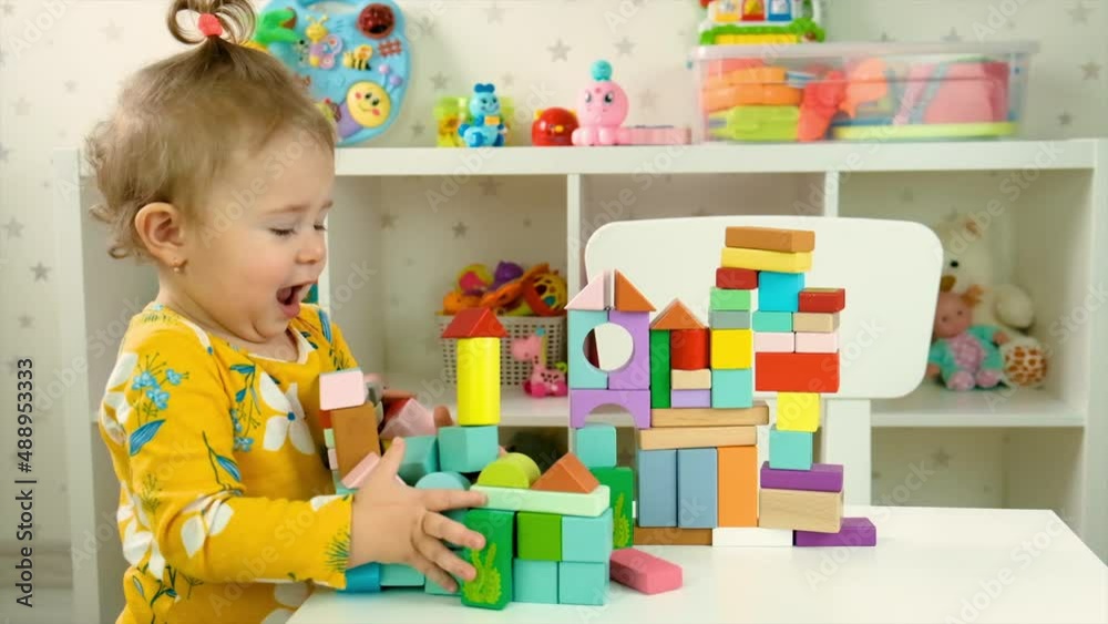 The child plays with toys in the room. Selective focus.