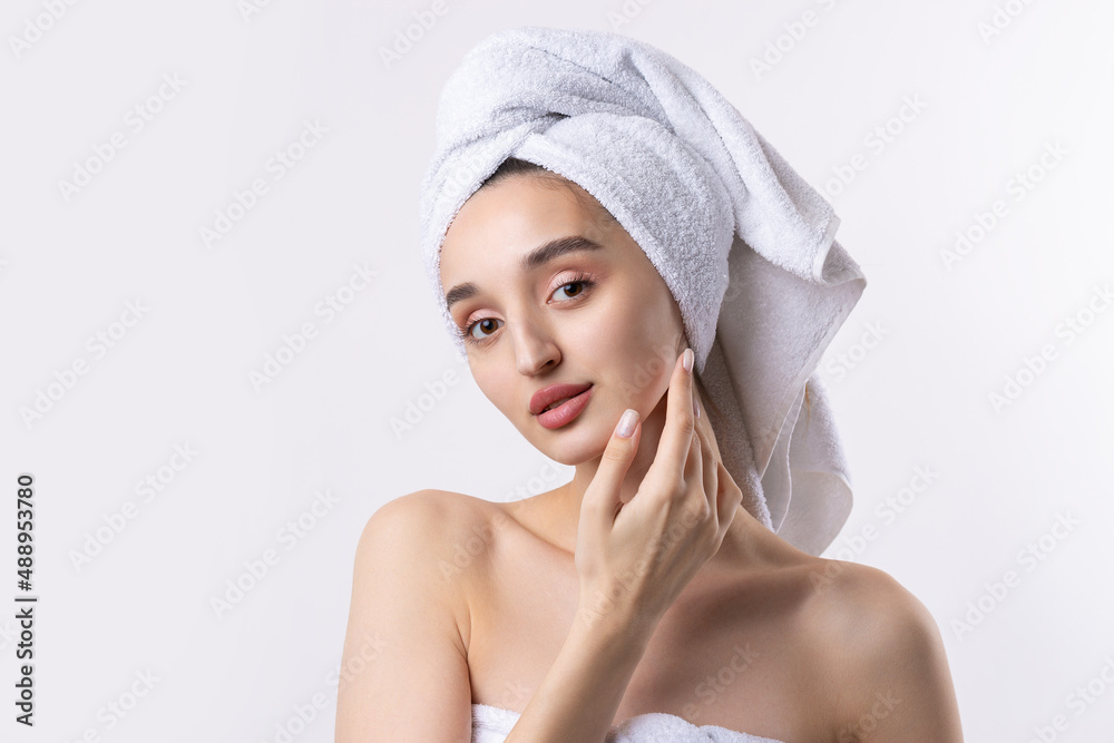Beautiful girl with thick eyebrows and perfect skin at white background, towel on head, beauty photo. Beautiful girl with thick eyebrows and perfect skin at white background, towel on head, beauty photo.