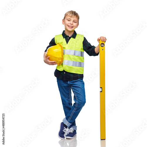 building, construction and profession concept - happy smiling little boy in protective helmet and safety vest with level over white background