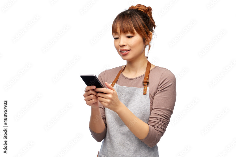 cooking, technology and people concept - happy smiling female chef or waitress in apron showing smartphone with empty screen over white background cooking, technology and people concept - happy smiling female chef or waitress in apron showing smartphone with empty screen over white background