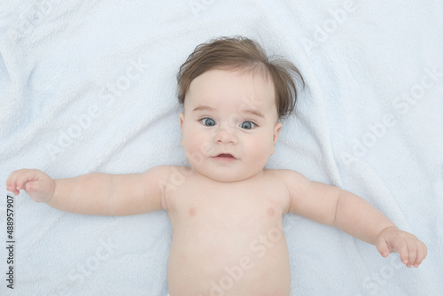 beautiful baby boy four months old lying on a blue soft blanket