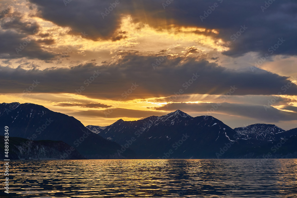 Sea sunset on the background of volcanoes and mountains. Kamchatka, Russia. Sea cruises and travel