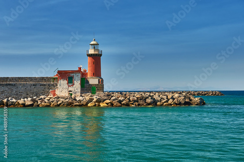 Lighthouse on the background of a beautiful sea and sky. Sea cruises and travel