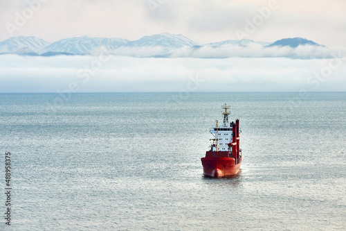Ship in the sea on the background of volcanoes. Gas and oil transportation industry