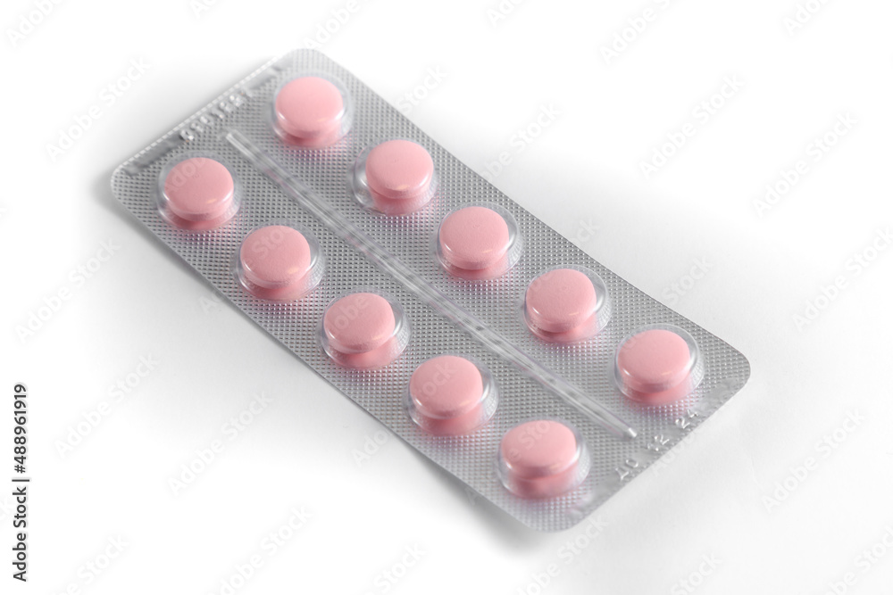 Close-up of a couple white pills or capsules on isolated white background. Close-up of a couple white pills or capsules on isolated white background.