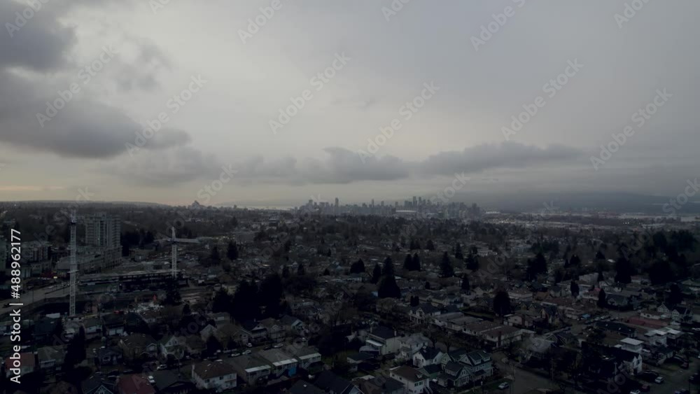 Aerial view of Downtown Vancouver during a cloudy day, drone fly above Neighbourhood with modern skyline view of the Metropoli of Canada at distance Aerial view of Downtown Vancouver during a cloudy day, drone fly above Neighbourhood with modern skyline view of the Metropoli of Canada at distance