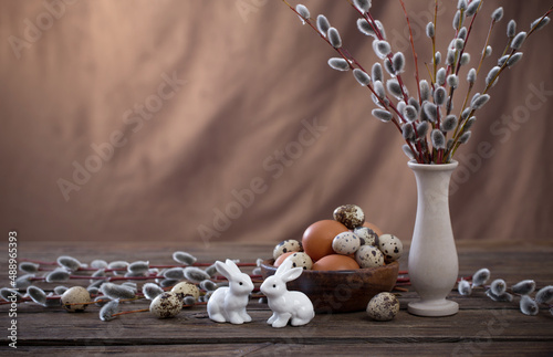 Easter eggs and willow branches on brown background