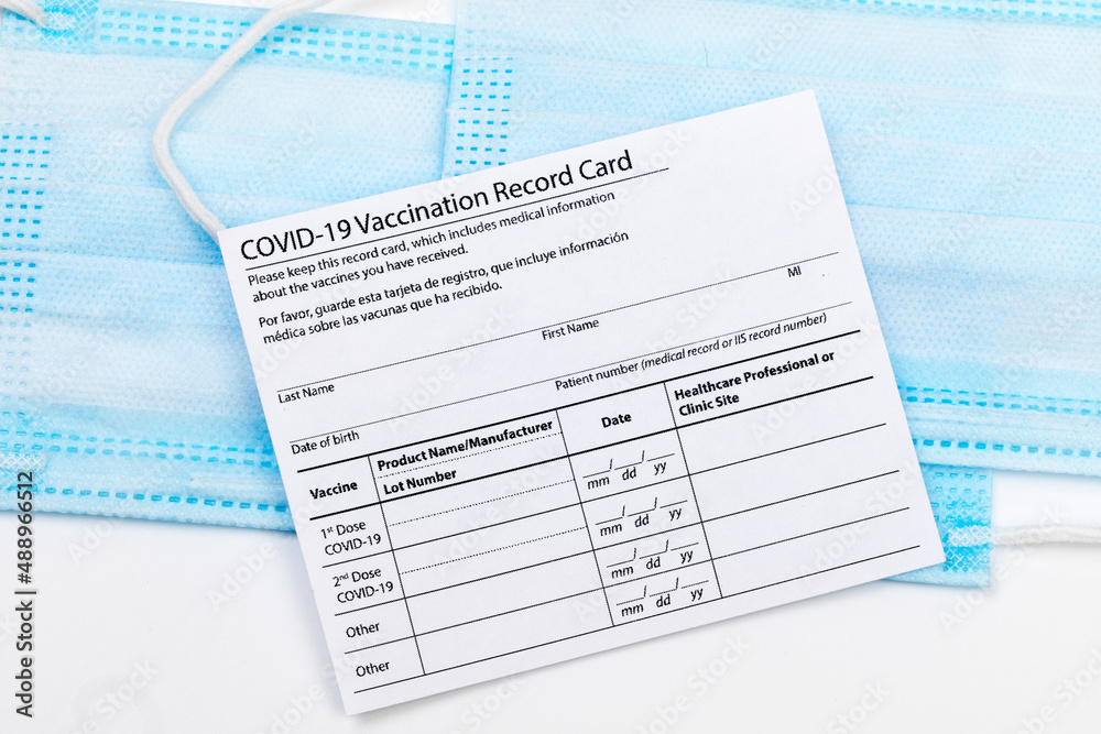 Obraz premium Coronavirus vaccination record card. Protective mask divided into two parts. Concept of defeating Covid-19 - Image