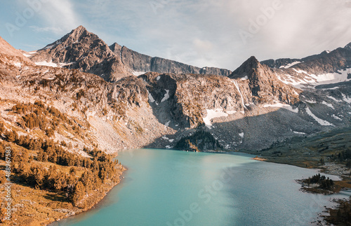 Atmospheric and moody aerial drone point of view of turquoise Krepkoe Lake at sunset in Altai, Russia. National park and natural wonders background