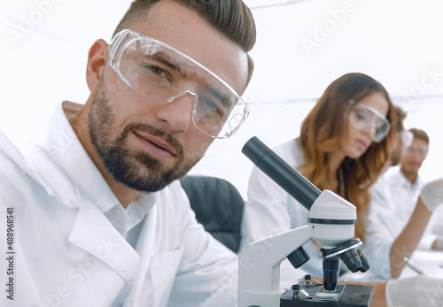 close-up of a scientific researcher with microscope