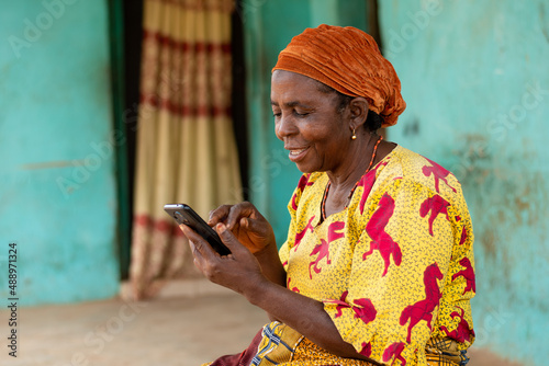 happy elderly african woman using her mobile phone