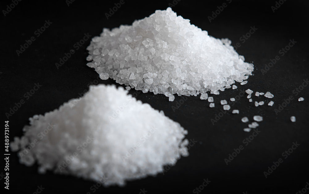 White coarse sea salt on a black background