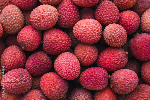 many ripe juicy red lychees close up - horizontal food background