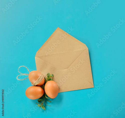 easter eggs with greenery in an envelope, copy space for text, promo or message. easter greeting or sale concept photo