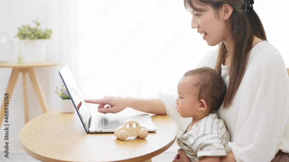 ノートパソコンを赤ちゃんに見せる母親 ノートパソコンを赤ちゃんに見せる母親