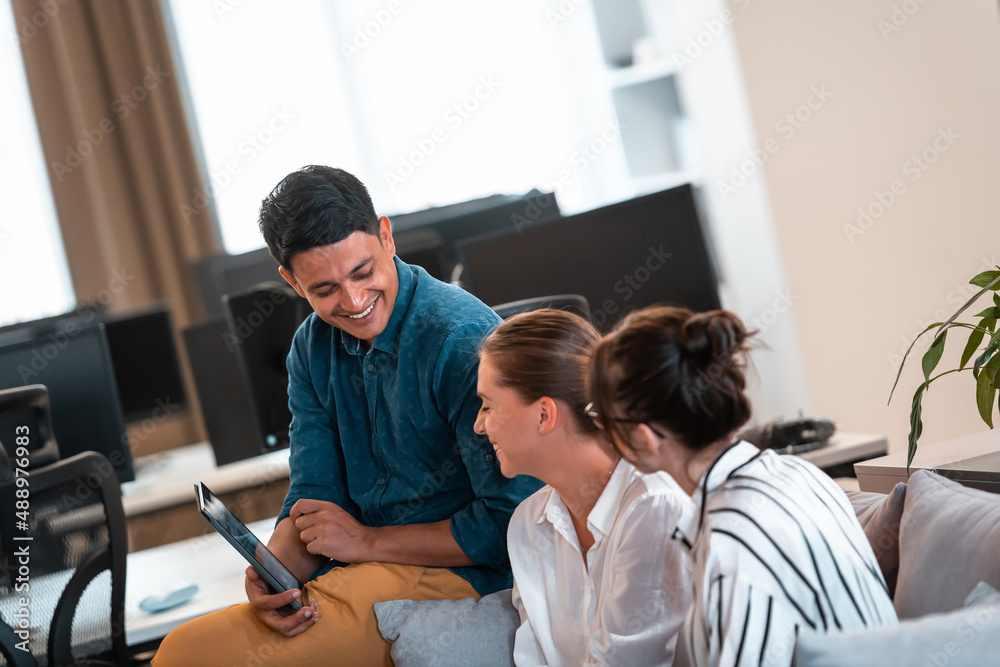Group of casual multiethnic business people taking break from the work doing different things while enjoying free time in relaxation area at modern open plan startup office