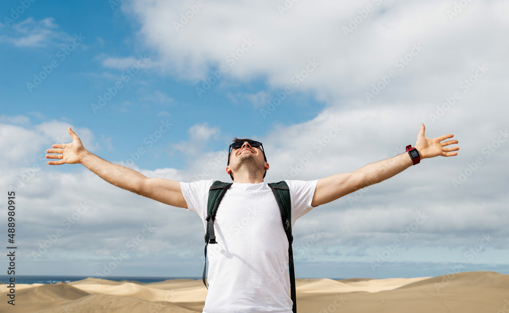 Brunet man opened hands, rice up and smiling at desert.