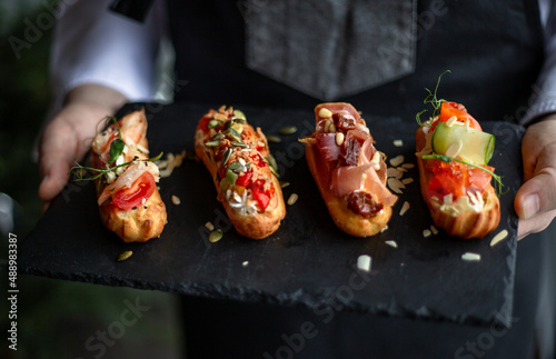 Eclairs with salmon, fresh vegetables and herbs, gourmet snacks.