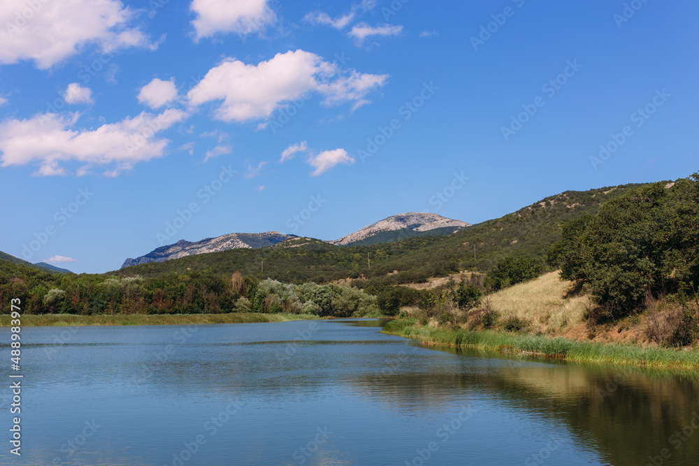 Beautiful lake in the Crimean mountains among greenery and flowers