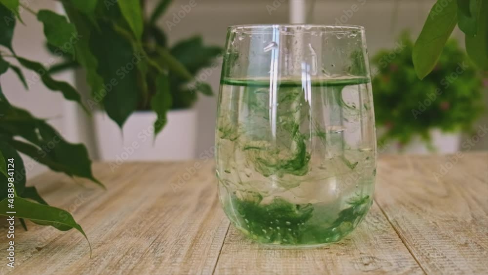 Liquid chlorophyll in a glass of water. Selective focus. Liquid chlorophyll in a glass of water. Selective focus.
