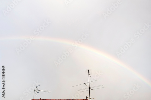 Rainbow in the sky with TV antennas in the foreground photo