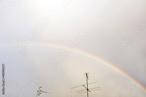 Rainbow in the sky with TV antennas in the foreground. photo