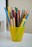 Yellow glass with colored pencils and funny pens