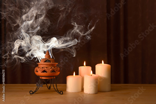Fotografía incense burning in an incense burner with candles on the table for praying Buddha or Hindu gods to show respect