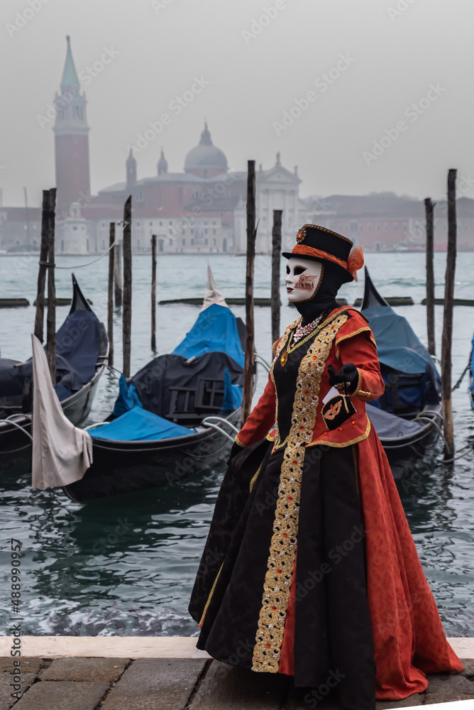 Karneval in Venedig, maskierte Dame mit Gondeln und San Giorgo Maggiore im Hintergrund