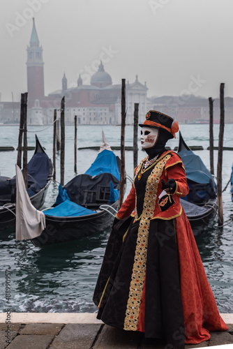 Karneval in Venedig, maskierte Dame mit Gondeln und San Giorgo Maggiore im Hintergrund