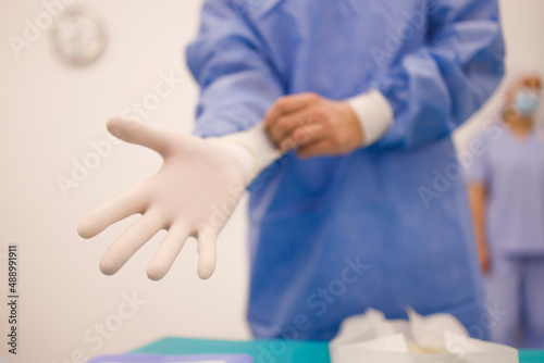 Surgeon getting ready for a procedure by putting on sterile gloves