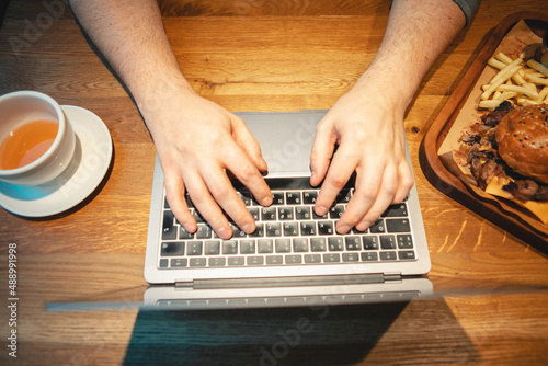 overhead view hands type on keyboard wooden table