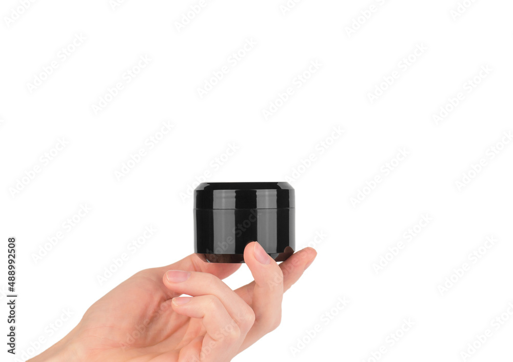 Skin care concept. Male hand holding a black jar of moisturizer on a white background, mockup Skin care concept. Male hand holding a black jar of moisturizer on a white background, mockup
