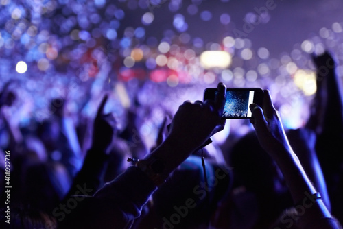 Never forget this moment. An audience member taking a photograph of the crowd at a music festival.