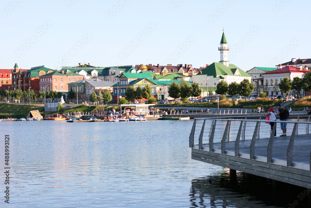 The Lake Nizhny Kaban. Kazan, Tatarstan, Russia: July 14 2021. The embankment of the Lower Kaban Lake. Tourists are walking and boating. Photo with copy space. Panoramic view of the embankment