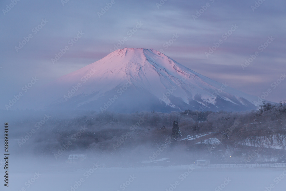 雪景色の山中湖から朝もやにかすむ富士山