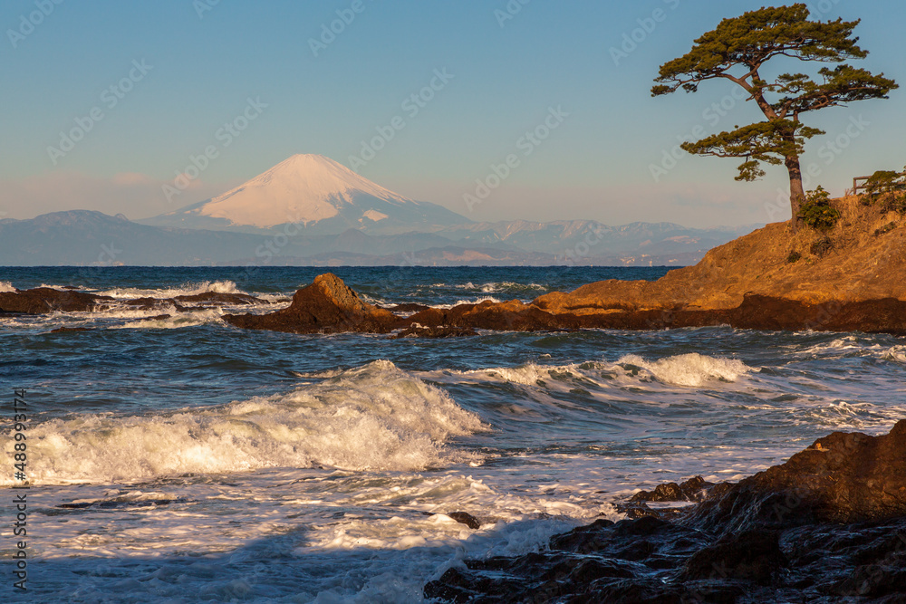 横須賀市秋谷立石公園から荒波洗われる岩礁と朝の富士山