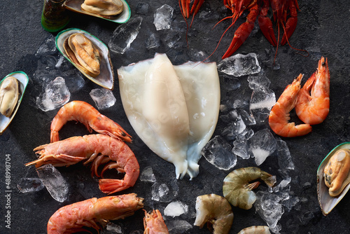 Assortment of various raw seafood - shrimps, kiwi mussels, squid and crawfish on ice photo