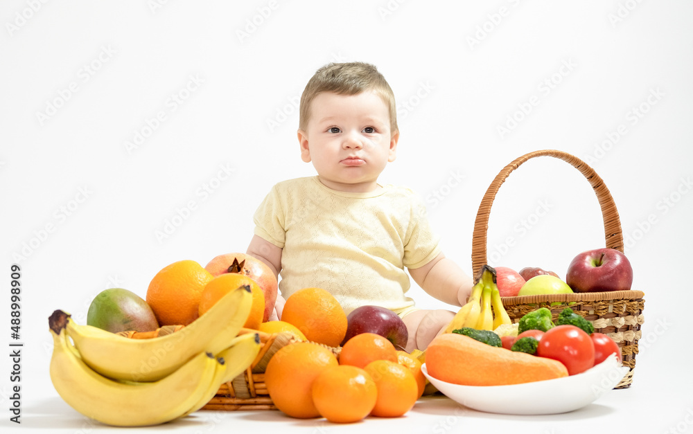 Cute baby boy sitting with fruits and vegetables isolated on white background healthy food feed baby Cute baby boy sitting with fruits and vegetables isolated on white background healthy food feed baby