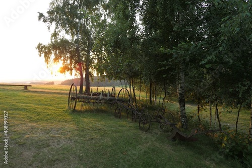 Antique iron farm machinery at sunset