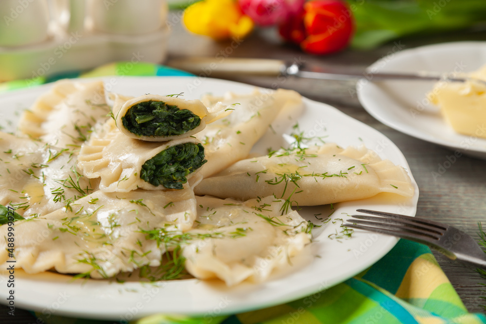 Dumplings with spinach, topped with melted butter and sprinkled with chopped dill Dumplings with spinach, topped with melted butter and sprinkled with chopped dill