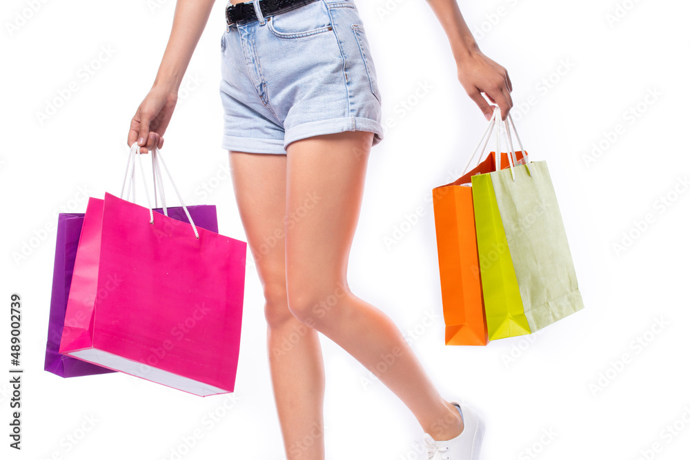 Shopping summer sale concept. Woman holding many shopping bags in hand after day shopping summer sale isolated on white background.