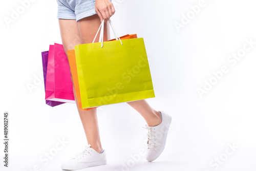 Shopping summer sale concept. Woman holding many shopping bags in hand after day shopping summer sale isolated on white background.