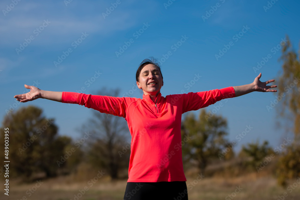 Cheerful athletic senior woman. Positive elderly woman is doing exercises. Portrait of a sporty elderly woman in the park Cheerful athletic senior woman. Positive elderly woman is doing exercises. Portrait of a sporty elderly woman in the park