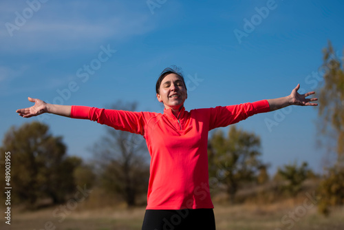 Cheerful athletic senior woman. Positive elderly woman is doing exercises. Portrait of a sporty elderly woman in the park