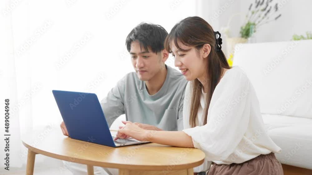 ノートパソコンを見る若い男性と女性 ノートパソコンを見る若い男性と女性