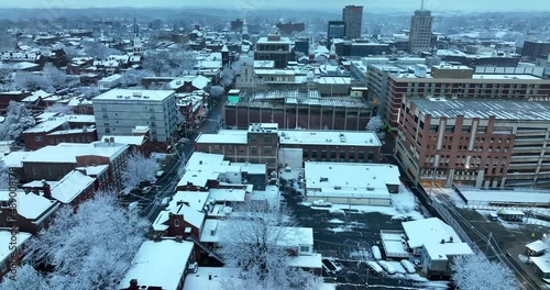 Truck shot of American city at daybreak with fresh winter snowfall. Urban buildings, parking garage, skyscrapers. photo