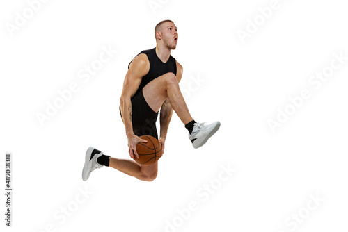 Dynamic portrait of basketball player jumping with ball isolated on white studio background. Sport, motion, activity concepts. Dunk, jam, stuff technic