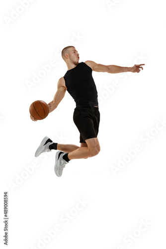 Dynamic portrait of basketball player jumping with ball isolated on white studio background. Sport, motion, activity concepts. Dunk, jam, stuff technic